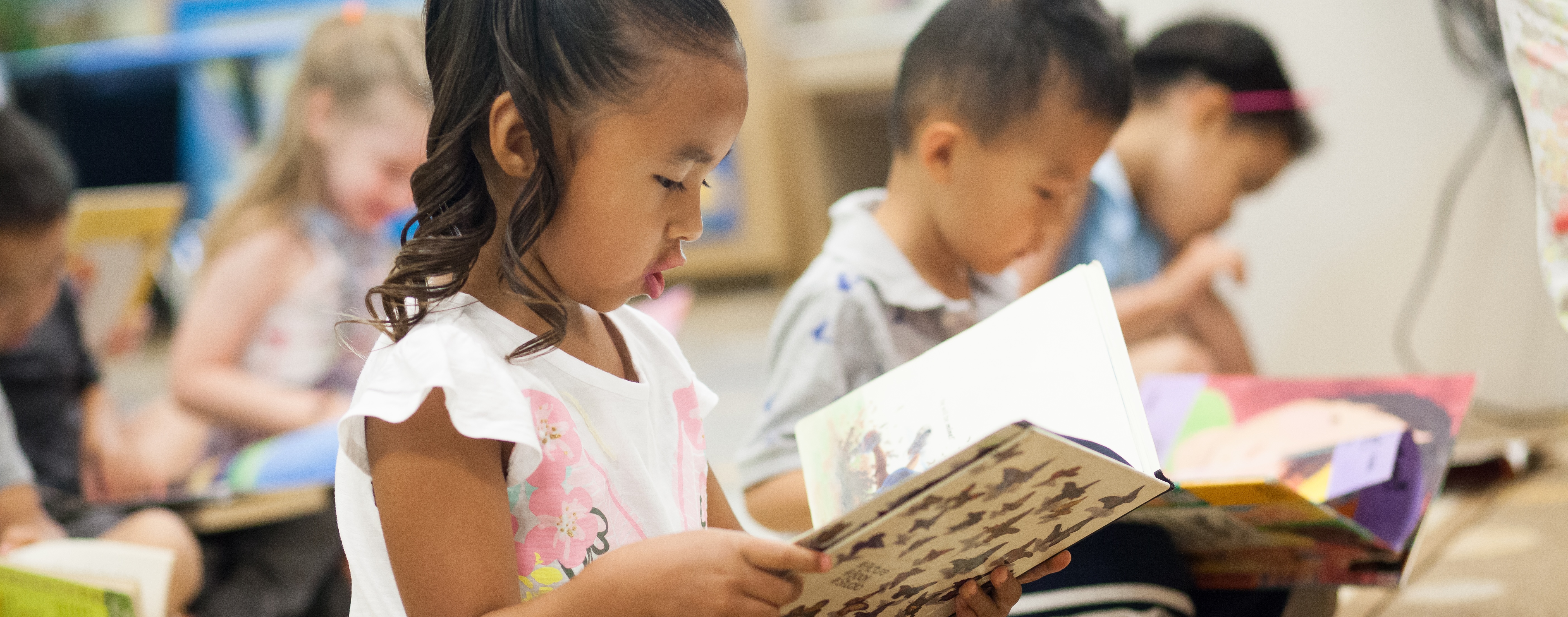 Children read while sitting on the floor.