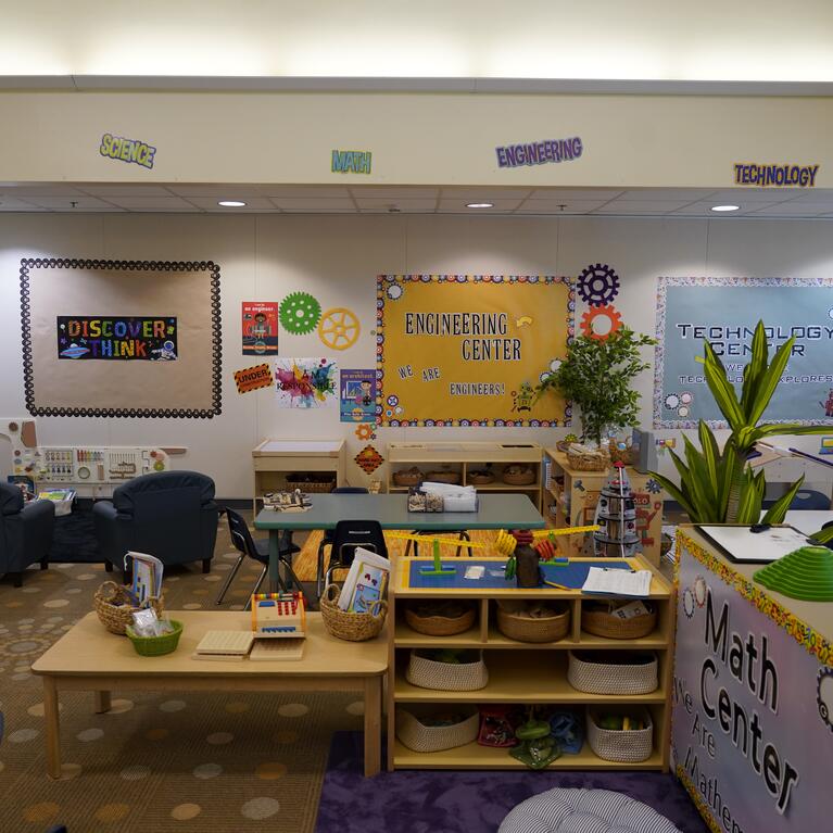 A STEAM room with "STEAM" on the wall, and math, art, science, technology, and engineering centers.