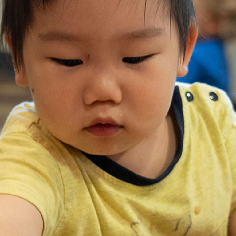 two toddlers playing at table